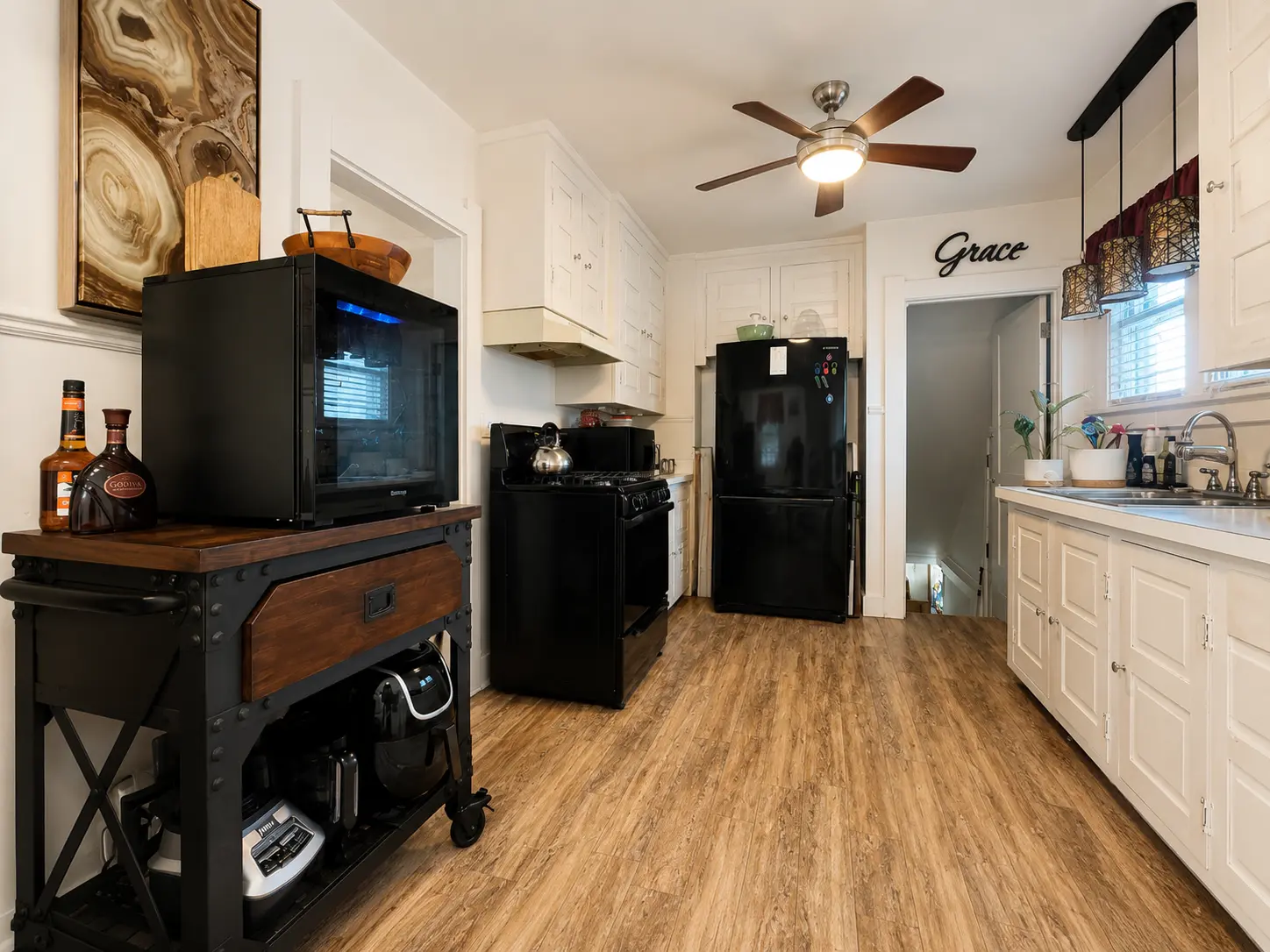 Kitchen at 3718 Revere Drive with a gas range, refrigerator, white cabinetry, and ceiling fan