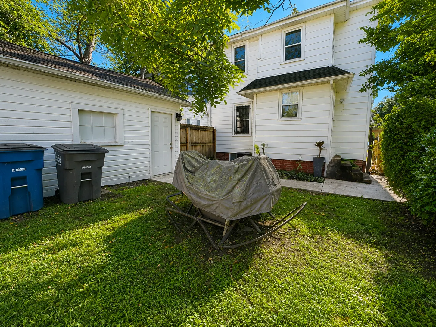 Backyard at 3718 Revere Drive showing the one-car garage with side entry and the rear of the house