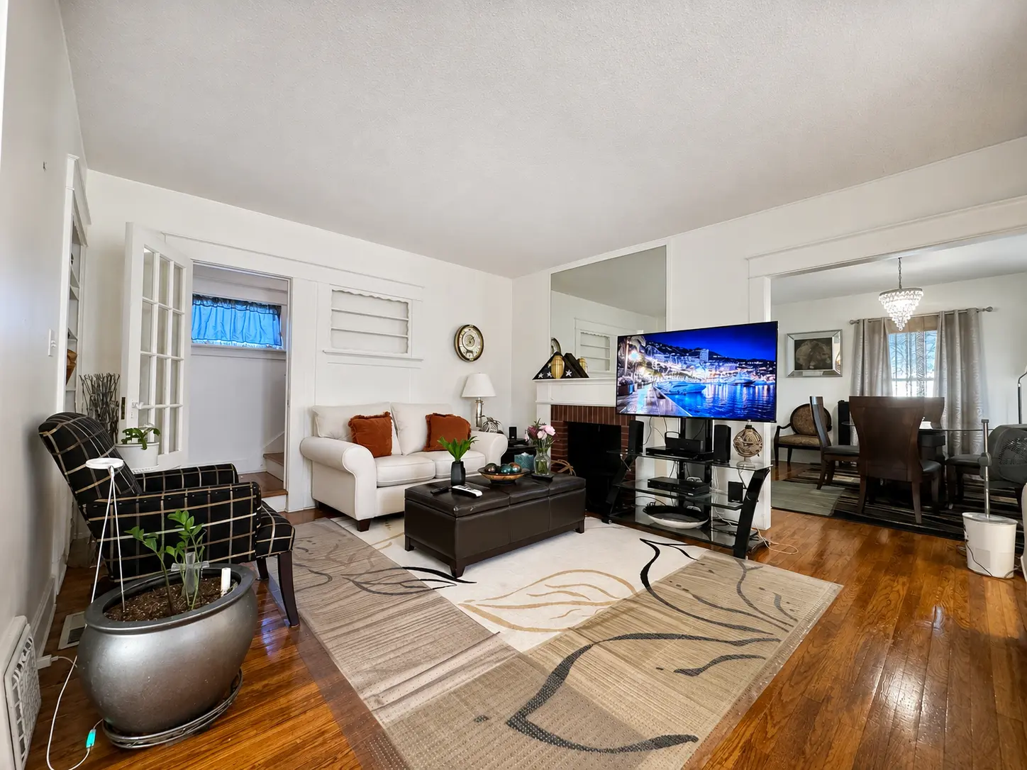 Wide view of the living room at 3718 Revere Drive opening to the dining room with a chandelier