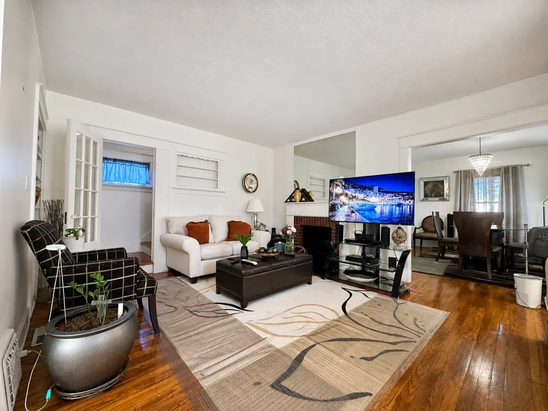 Wide view of the living room at 3718 Revere Drive opening to the dining room with a chandelier
