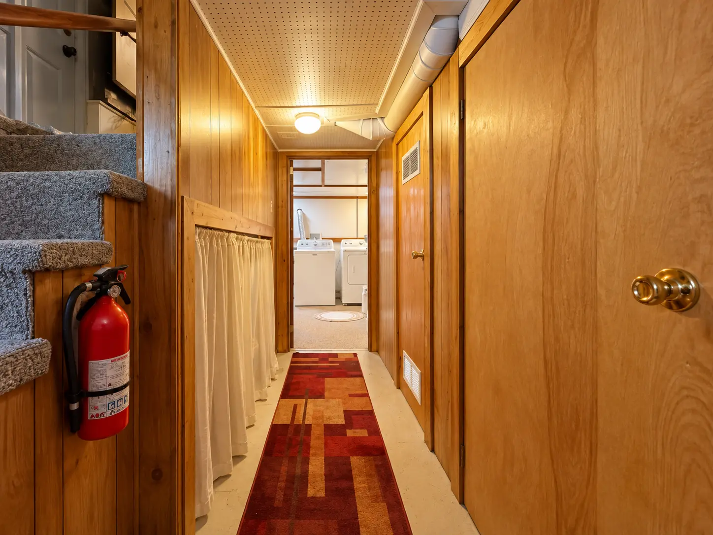 Basement hallway at 3718 Revere Drive leading to the laundry room with washer and dryer
