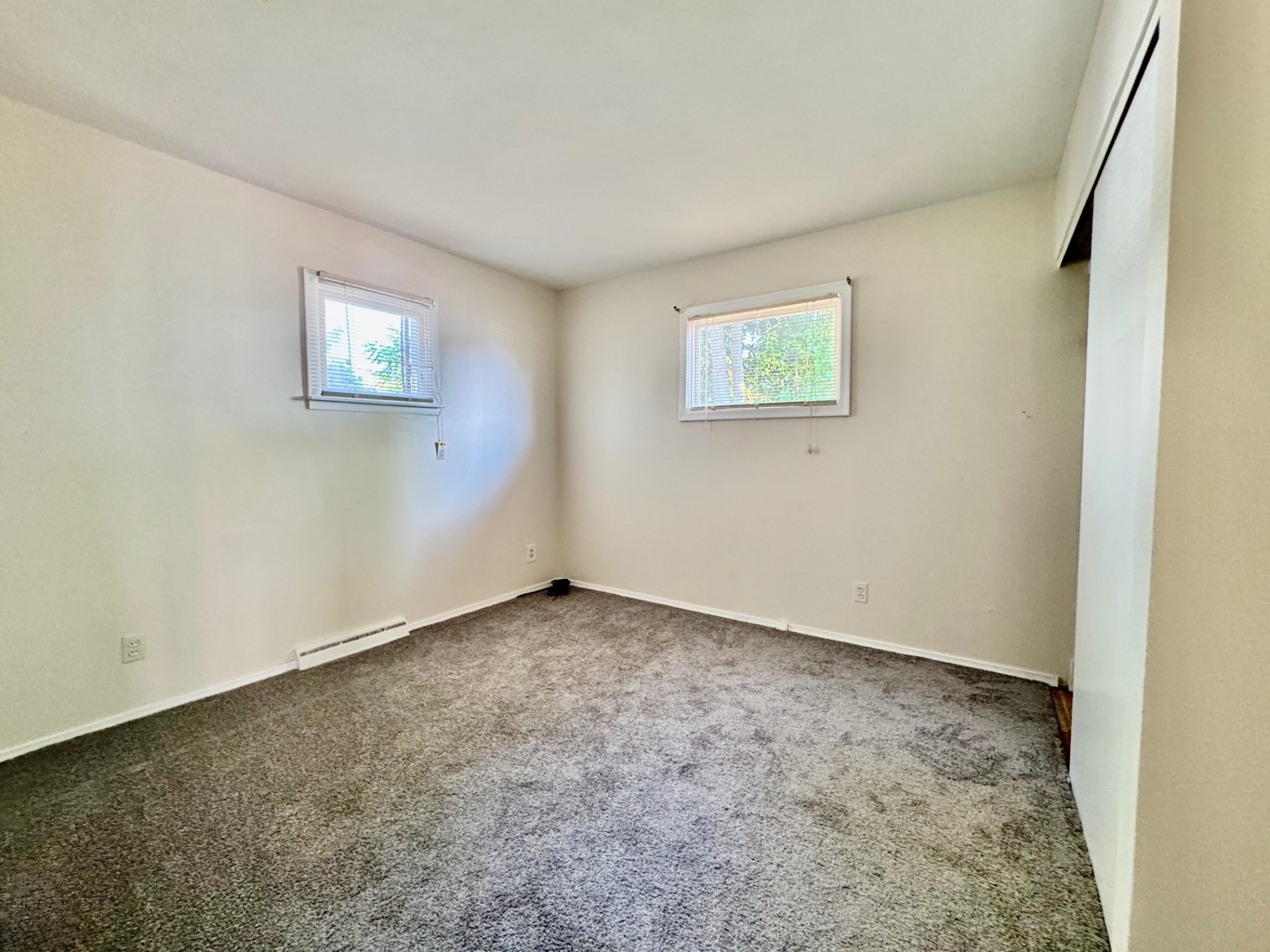 Bedroom one with fresh carpet and natural light