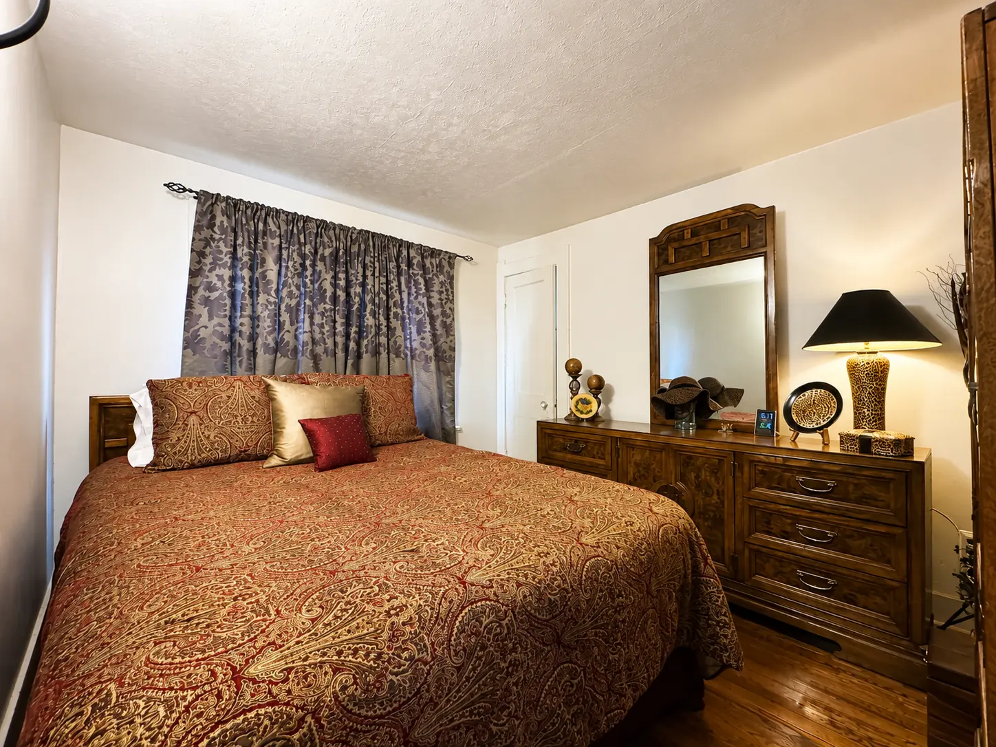Third bedroom at 3718 Revere Drive with a queen bed, dresser with mirror, and hardwood floors