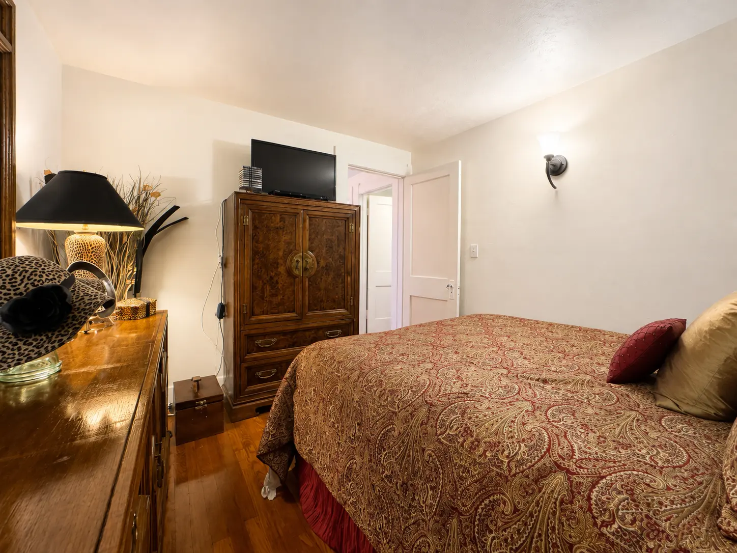 Second view of the third bedroom at 3718 Revere Drive showing the armoire and doorway to the hallway