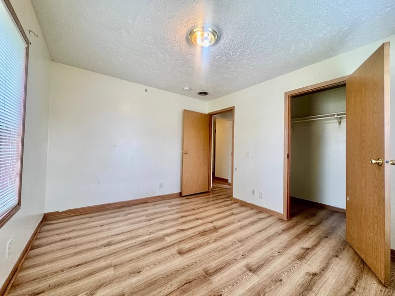 Bedroom with laminate flooring and closet