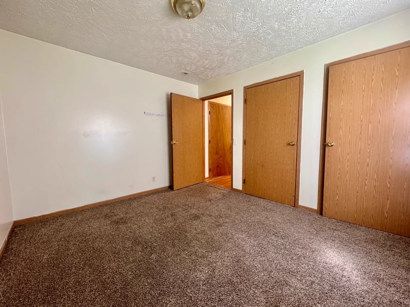 Carpeted bedroom with two closets