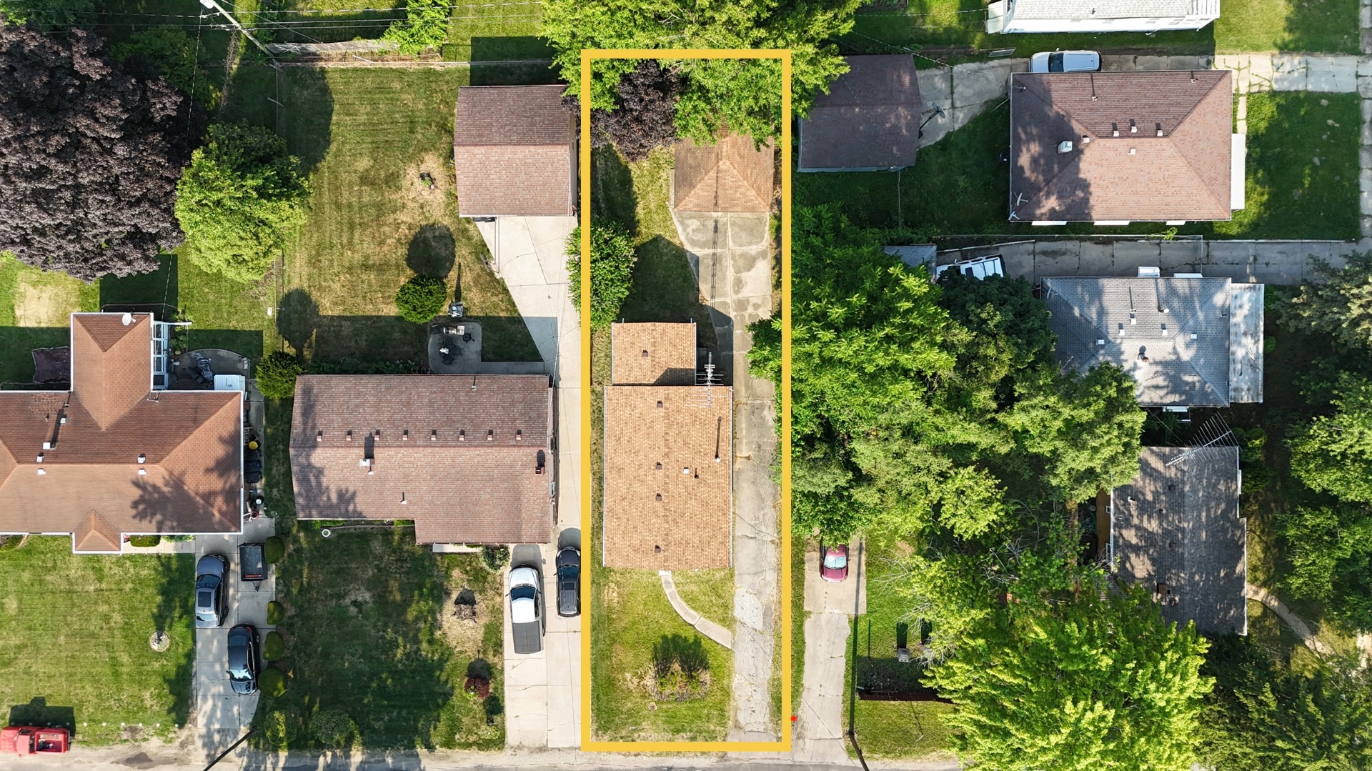 Top-down aerial showing the full property lot lines, house, driveway, and detached two-car garage