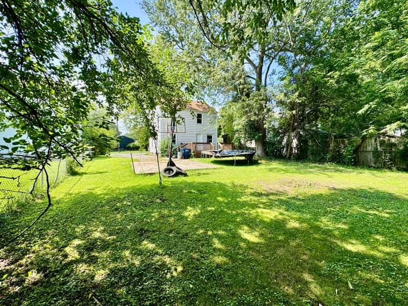 Wide backyard at 510 Richards Road with mature shade trees