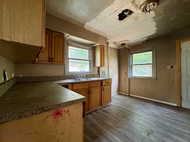 Kitchen at 510 Richards Road with sink, wood cabinets, and two windows