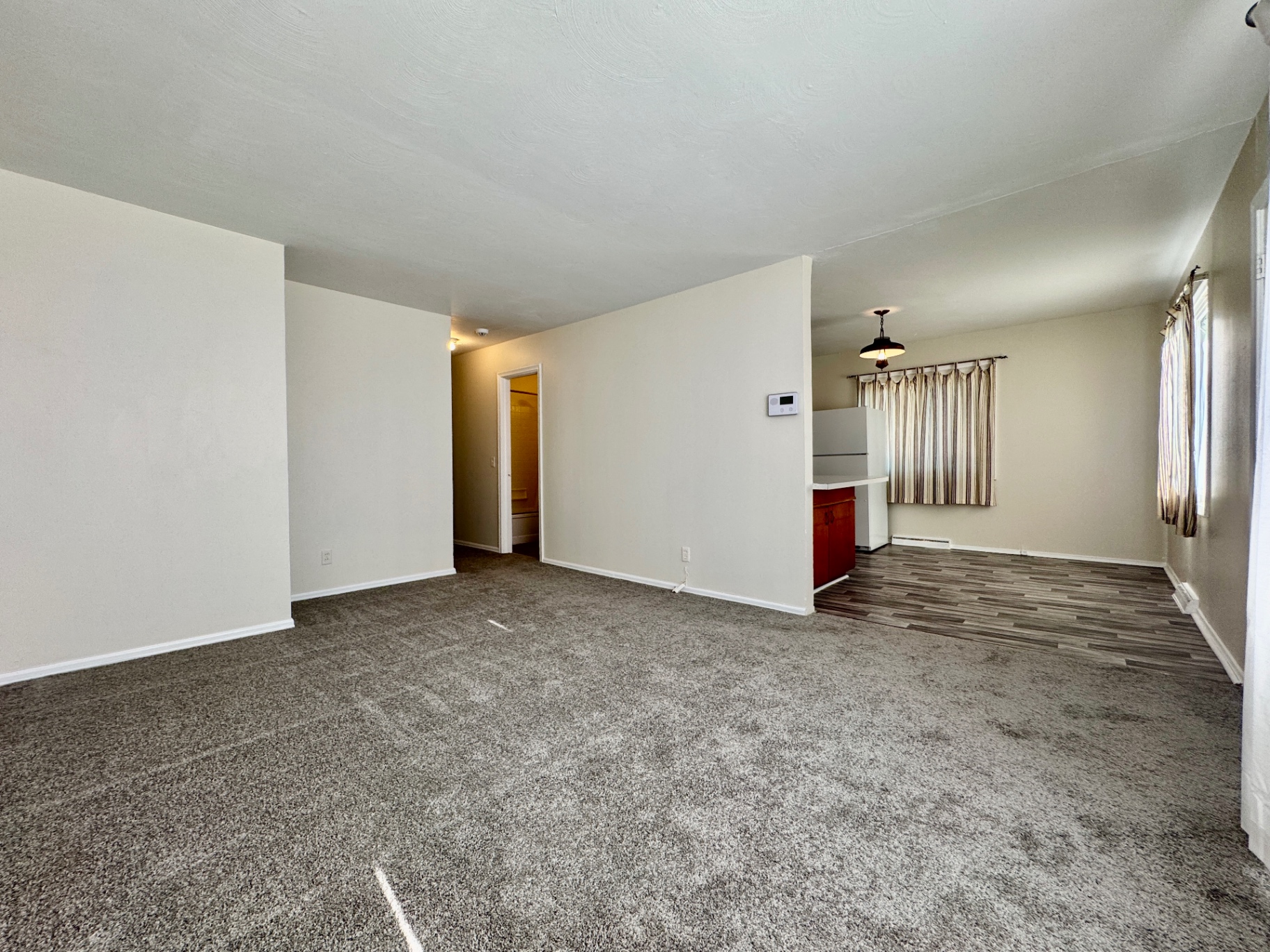 Wide view of the living room opening into the kitchen