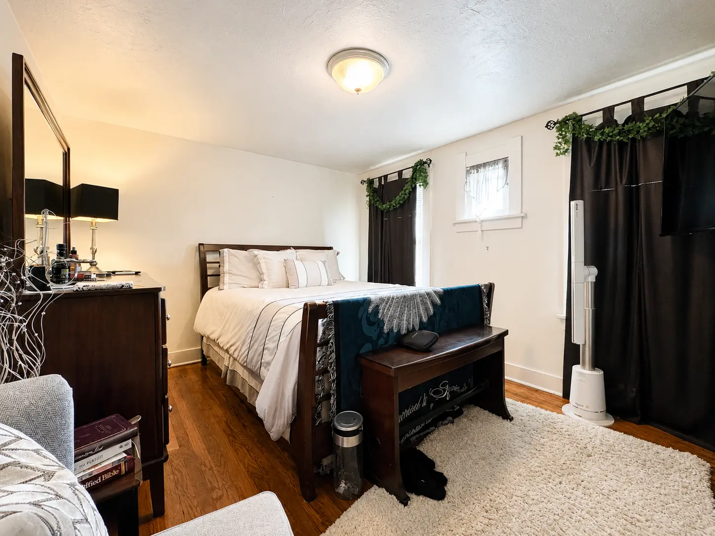 Second view of the bedroom at 3718 Revere Drive with a sleigh bed, bench, and hardwood floors